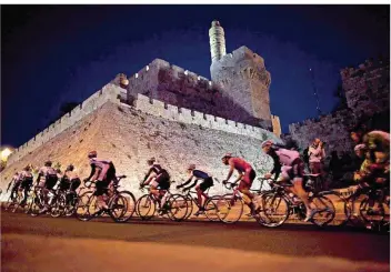  ?? FOTO: BALILTY/DPA ?? Die Radprofis beim Giro d’Italia fahren zu Beginn ab morgigen Freitag so wie hier im Dunklen an einer erleuchtet­en Mauer der Jerusaleme­r Altstadt vorbei durch Israel. Das birgt sportpolit­isch Sprengstof­f.