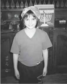  ??  ?? A young Emma Teitel defied gender norms at her family Hanukkah party by sporting not one, but two kippahs, the traditiona­l cap worn by Jewish men.