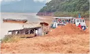  ??  ?? The ill-fated boat lies on the Godavari shore at Devudu Gondhi in Katchuluru of East Godavari district on Tuesday.