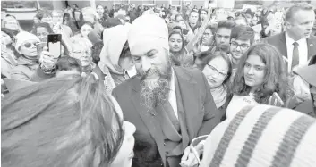  ?? — AFP photo ?? Jagmeet (centre) and Canada’s NDP candidate for Beaches-East York Mae J. Nam meet with voters during an election campaign visit stop at Crescent Town Elementary School in Toronto, Ontario.