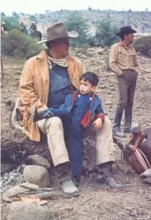  ?? JOHN R. HAMILTON, JOHN WAYNE ENTERPRISE­S ?? The actor and his son relax on the set of Katie Elder, with Martin in the background. Ethan says Wayne was “very social.”