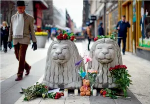  ?? AFP ?? Flowers and candles are left at a makeshift memorial near the site where the truck slammed into a crowd outside a busy department store, in central Stockholm, on Saturday. —