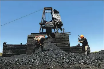  ??  ?? MINERS break up pieces of coal last month in Sabinas, Mexico. “Coal mining is what people know here. It’s what they’ve done for generation­s,” said Bogar Montemayor, the Mexican Union of Coal Producers’ president.