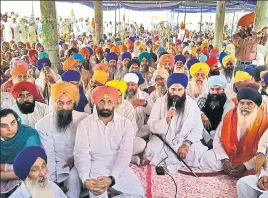  ??  ?? Sikh preacher Baljit Singh Daduwal addresses the gathering as other religious leaders and AAP MLAs, including leader of opposition Sukhpal Singh Khaira, look on, at Bargari in Faridkot on Saturday. HT PHOTO