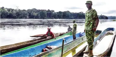  ??  ?? KONGO BOUMBA: Rangers stop pirogues to check they do not transport weapons or other forbidden goods, on a stretch of the Ivindo river in the Ivindo National Park in Gabon. At the sprawling Ivindo national park in central Gabon, wildlife guards in...