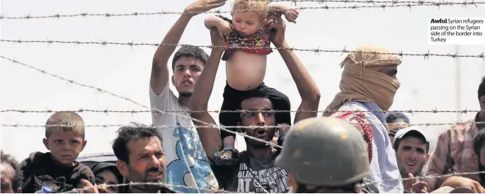  ??  ?? Awful Syrian refugees passing on the Syrian side of the border into Turkey