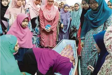  ??  ?? PELAJAR USIM melihat jenazah arwah Wamasaria buat kali terakhir sebelum dibawa pulang ke Kampung Kitagas Sandakan Sabah.untuk dikebumika­n.