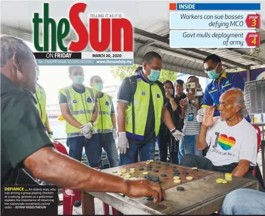  ?? ASYRAF RASID/THESUN ?? DEFIANCE ...
An elderly man, who was among a group playing checkers at a warung, gestures as a policeman explains the importance of observing the nationwide movement control order. –