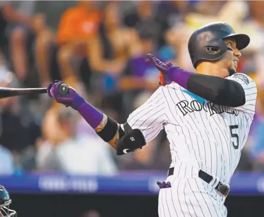  ?? Andy Cross, The Denver Post ?? Rockies right fielder Carlos Gonzalez watches the flight of his three-run homer against the Diamondbac­ks during the fourth inning Wednesday night at Coors Field. It was Gonzalez’s second homer of the night as Colorado took Arizona pitching deep five times.