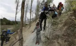  ?? YANNIS BEHRAKIS/REUTERS ?? Migrants from Somalia are seen trying to reach Greece’s border with Macedonia.