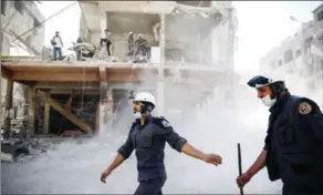  ?? SAMEER AL-DOUMY/AFP ?? Syrian civil defence volunteers, known as the White Helmets, work around destroyed buildings following reported air strikes on the rebel-held town of Douma, on the eastern outskirts of the capital Damascus on October 5, 2016.