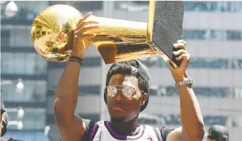  ?? DAN HAMILTON/USA TODAY SPORTS/FILES ?? Toronto Raptors guard Kyle Lowry shows off the Larry O’Brien Trophy to fans during the victory parade through downtown Toronto on June 17 to celebrate their historic NBA title.