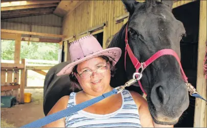  ?? MILLICENT MCKAY/JOURNAL PIONEER ?? Karen Chapman pets horse Cinderella’s Fantasy at the Grand River Ranch. Heather Blouin and her husband run the ranch. They offer services for those with special needs to come to the ranch and learn new skills.