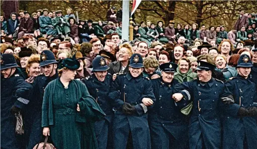  ??  ?? Laughing policemen: the happy crowd stretch the thin blue line as they await the approach of the royal couple