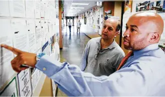  ?? Michael Ciaglo photos / Houston Chronicle ?? Jeff Van Gundy, left, perusing college acceptance letters for Pro-Vision students with principal Andre Credit, said he was impressed with how the school’s founder, former NFL star Roynell Young, left the game behind to help kids. “This is his life’s...