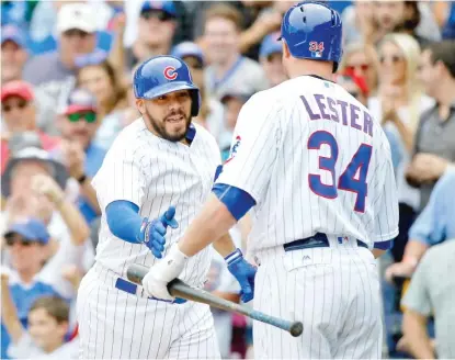  ??  ?? Rene Rivera is congratula­ted by Jon Lester after hitting a grand slam in the second inning Saturday. | JON DURR/ GETTY IMAGES