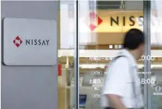  ?? — Reuters ?? Man walks past a branch of Nippon Life Insurance Company in Tokyo.