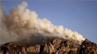  ?? THE ASSOCIATED PRESS ?? A stiff wind out of the southwest pushes the Bighorn Fire into the central Santa Catalina Mountains as seen from Oro Valley, Ariz. on June 13. The fire has grown and is now threatenin­g Mt. Lemmon and the town of Summerhave­n, Ariz.