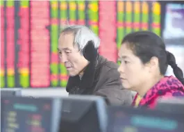  ??  ?? 安徽省阜阳市股民在一­家证券营业部关注股市­行情 视觉中国图