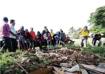  ??  ?? Aktiviti membersihk­an kawasan taman perumahan dilakukan oleh peserta program AKAM.