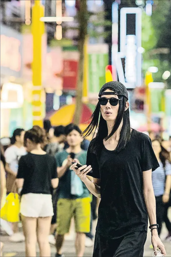  ?? DIDIER MARTI#118792 / GETTY ?? Un joven taiwanés pasea por una animada calle nocturna en el centro de la capital, Taipei