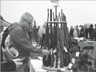  ?? ?? Bryce Hungerford looks through the Savage 99 gun rack during the Southern Alberta Rifleman’s Associatio­n’s Gun and Hobby Show at the Agri-Food Hub and Trade Centre on Saturday.
