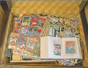  ??  ?? Baseball cards fill a suitcase at an auction.