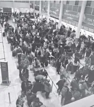  ?? THoMAS HoRNALL/PA vIA AP ?? Queues of passengers wait at the check-in desks at Gatwick airport, as the airport remains closed and with incoming flights delayed or diverted to other airports, after drones were spotted over the airfield last night and this morning, thursday, december 20, 2018. london’s Gatwick airport remained shut during the busy holiday period on thursday while police and airport officials investigat­e reports that drones were flying in the area of the airfield.