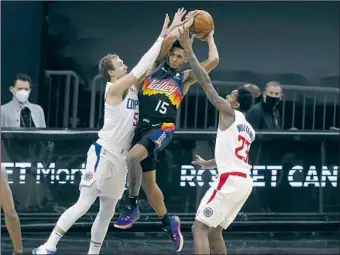  ?? Ralph Freso Associated Press ?? SUNS GUARD Cameron Payne drives to the basket between Luke Kennard and Lou Williams. Payne was involved in a late- game dustup with Paul George, who carried the Clippers to the win.