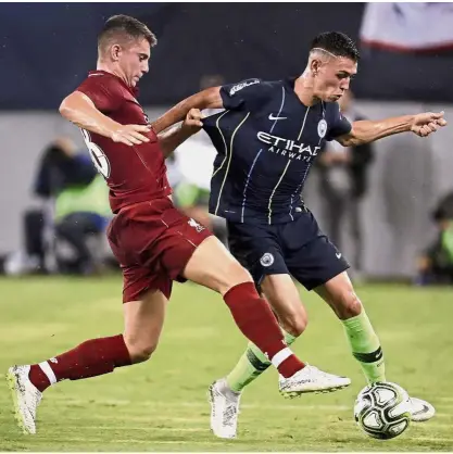  ?? — AP ?? That’s mine: Liverpool forward Ben Woodburn (left) vying for the ball with Manchester City midfielder Phil Foden during the Internatio­nal Champions Cup match on Wednesday.