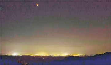  ??  ?? The blood moon pictured by Ross Davenport from the Devils Kneading Trough near Wye overlookin­g Ashford