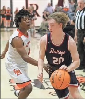  ??  ?? Heritage’s Carter Bell maneuvers around LaFayette’s Jaylon Ramsey during Friday’s Region 6-AAAA contest in LaFayette.