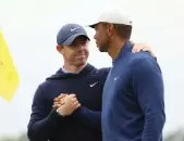  ?? Getty ?? Rory McIlroy and Tiger Woods shake hands on the 18th green at Augusta after a practice round for the 2023 Masters