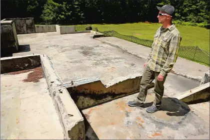  ?? TIM COOK/THE DAY ?? Eric Lindquist at the remains of his family’s home in Griswold on July 21. Lindquist’s mother, father and brother were murdered last December, after which the assailants allegedly burned down the family’s home. Eric, who was no longer living at the home, is the only surviving member of the family.