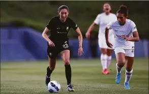  ?? Katharine Lotze / Getty Images ?? Christen Press of Angel City moves the ball down the field ahead of Yazmeen Ryan of the Portland Thorns during a game as part of the 2022 NWSL Challenge Cup at Titan Stadium on Sunday in Fullerton, Calif.