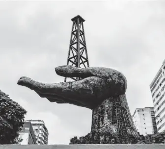  ?? Luis Robayo / AFP/Getty Images ?? A monument that pays homage to the struggles of the Venezuelan people sits in front of the headquarte­rs of Venezuelan state-owned oil company PDVSA in Caracas. About half of Venezuela’s crude exports go to the U.S., with most of them bought by Gulf Coast refineries.