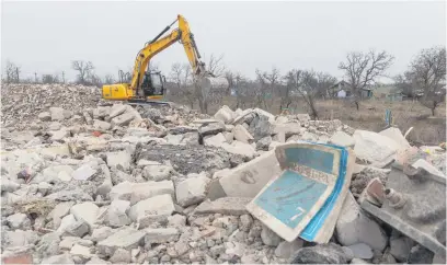  ?? Picture: AFP ?? ROCKY JOB. A former Ukrainian soldier, now employed by French Company Neo-Eco, uses an excavator to clear the debris of a school destroyed by Russian bombing in the village of Lyubomyriv­ka.