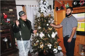  ?? Photo by Ernest A. Brown ?? Jalen Rodriguez, 16, left, and his older brother Chris, 22, decorate the family Christmas tree at their home in Woonsocket Thursday evening.