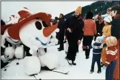  ?? (File Photo/AP) ?? A snowman mascot of the 1976 Winter Olympics in Innsbruck greets children in January 1975 in Kitzbuhel, Austria, during the world downhill ski events.