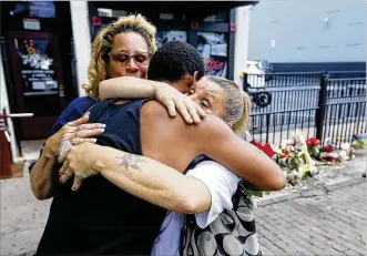  ?? TY GREENLEES / STAFF ?? Harry Payne is hugged by Jean Davies, left, and Mary K. Curtis as he arrived on East Fifth Street on Monday to leave flowers for his slain friend Logan Turner. Turner and eight other people were gunned down early Sunday morning in Dayton’s Oregon District leaving the district, the city and the nation to cope with the aftermath.