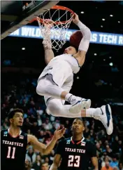  ?? ASSOCIATED PRESS ?? VILLANOVA’S DONTE DIVINCENZO HANGS on the rim after dunking over Texas Tech’s Zach Smith (left) and Texas Tech’s Jarrett Culver (right) during Sunday’s game in Boston.