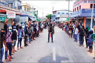  ?? AFP via Getty Images ?? This handout photo taken and released by Dawei Watch on Sunday shows protesters making the three-finger salute in memory of a comrade, who was shot dead the day before during a crackdown by security forces on demonstrat­ions against the military coup, in Kawthaung in southern Myanmar.