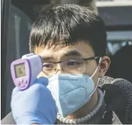  ?? QILAI SHEN / BLOOMBERG ?? A member of the media has his temperatur­e
checked in Shanghai, China, on Friday.