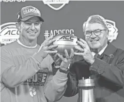  ??  ?? Clemson coach Dabo Swinney holds the ACC championsh­ip trophy with league Commission­er John Swofford on Dec. 7. JIM DEDMON/USA TODAY SPORTS