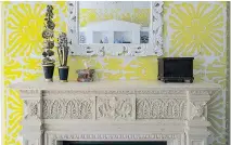  ??  ?? Susan Nelson and Todd Martz styled this mantel in a family room. The bold wallpaper called for a simple object to hang above the fireplace; the accessorie­s were chosen for their childlike qualities.