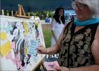  ?? JOE FRIES/Penticton Herald ?? Shirley Grant of local bereavemen­t group In Memoriam holds up one of the heartbreak­ing messages attached to a bulletin board set up Wednesday at the Internatio­nal Overdose Awareness Day event in Penticton.