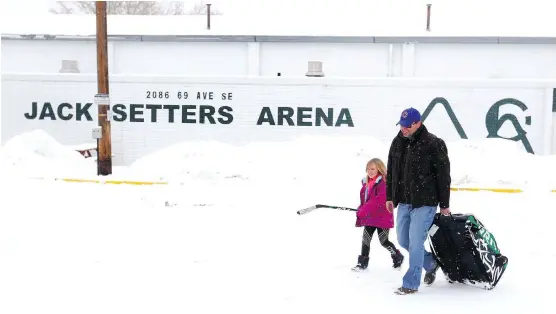  ?? JIM WELLS ?? Kyle Mortson and his daughter leave Jack Setters Arena in southeast Calgary on Sunday after learning the city closed the building because of concerns over snow load on the roof.