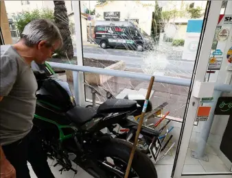  ?? (Photos Philippe Arnassan) ?? Le gérant de ce magasin de motos ne peut que constater les dégâts dans son enseigne après cette nuit de violences urbaines.