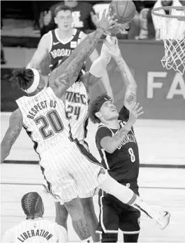  ?? CHARLES KING/ORLANDO SENTINEL ?? Nets guard Tyler Johnson (8) attempts a shot over Magic player Markelle Fultz (20).