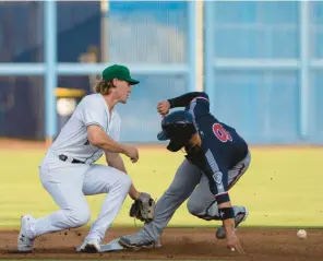  ?? BILLY SCHUERMAN/STAFF PHOTOS ?? Nashville Sounds catcher Mario Feliciano slides into second base as the throw gets away from Norfolk Tides shortstop Gunnar Henderson on Tuesday night at Harbor Park.